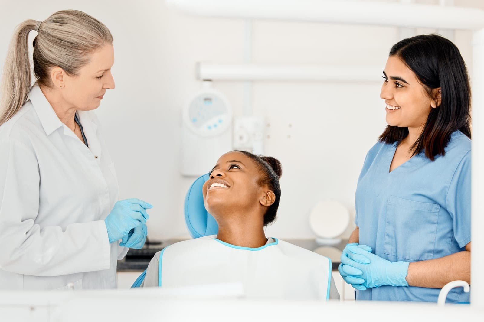A friendly dentist and nurse chatting with a smiling patient at Brewery Yard Dental Surgery